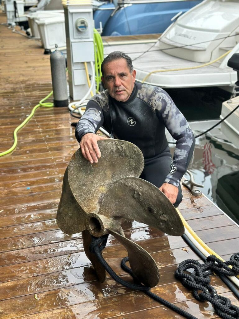 Aqua Pro diver on the dock with a propeller removed from a boat